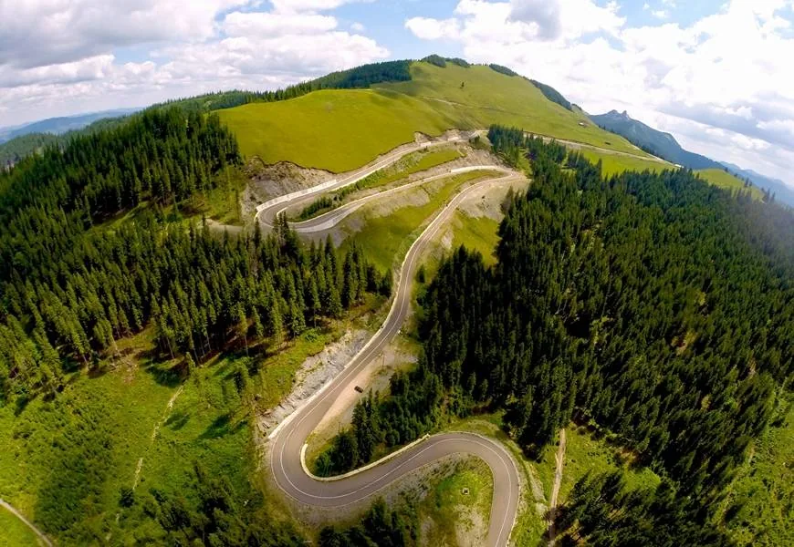 The Transrarău hairpins seen from above, between forest and meadows